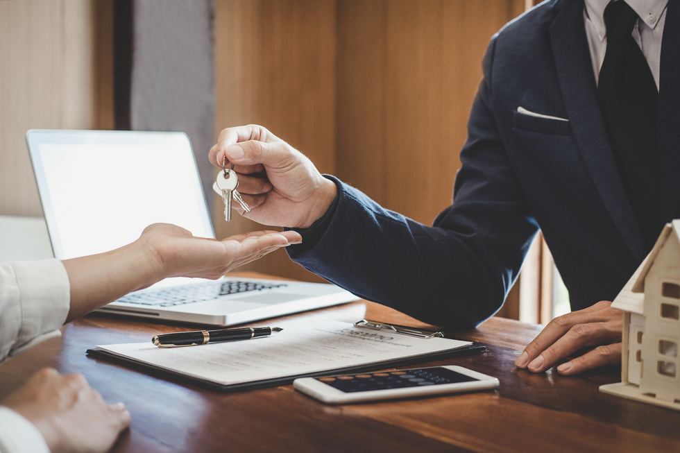 Real Estate Agent Sales Manager Holding Filing Keys to Customer